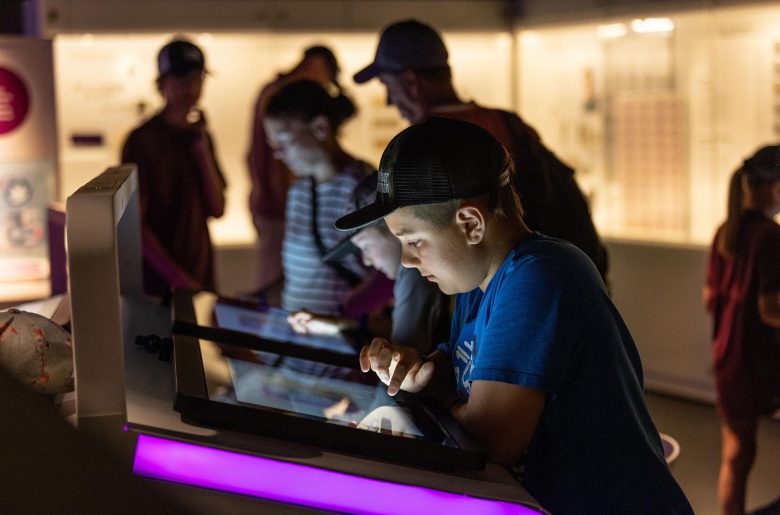 Un enfant utilise une des tablettes numériques du Musée de la Banque du Canada.