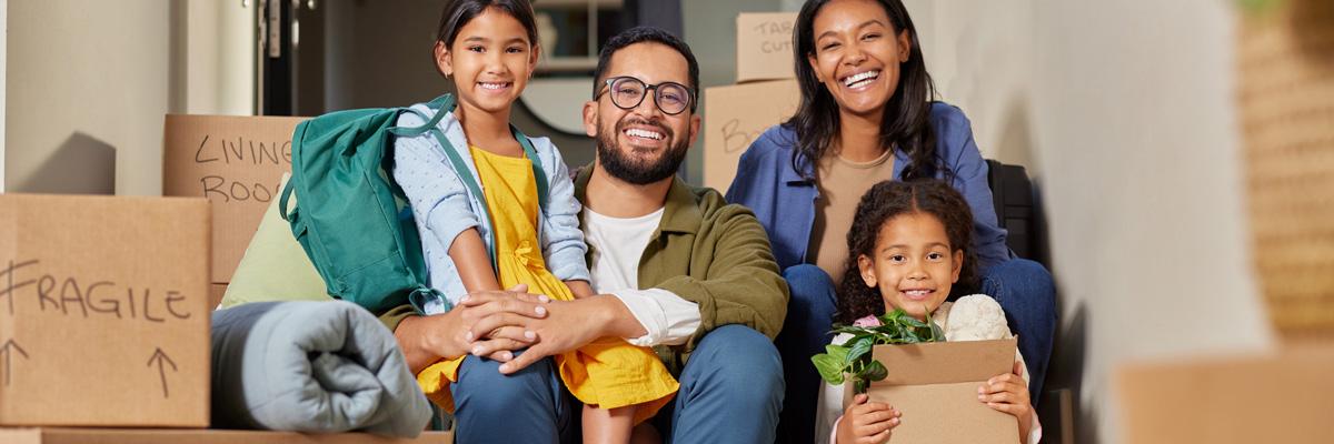 L’immigration stimule l’activité économique Une famille immigrante de quatre personnes est entourée de cartons de déménagement alors qu’elle s’installe dans son nouveau logement.
